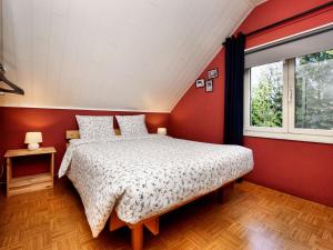 una camera con un letto su una parete rossa di Modern Holiday Home with Private Garden a Tenneville