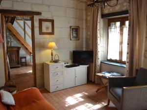 a living room with a tv and a couch and a table at Romantic Loire Hideaway in Brion