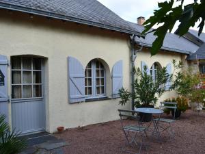 a house with blue windows and a table and chairs at Cozy Holiday Home in Brion with Swimming Pool in Brion
