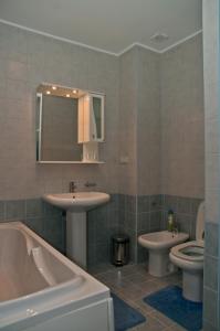 y baño con 2 lavabos, bañera y aseo. en Ligena Hotel en Boryspilʼ