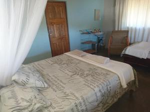 a bedroom with a bed with a white blanket at Gateway Guest House in Monkey Bay