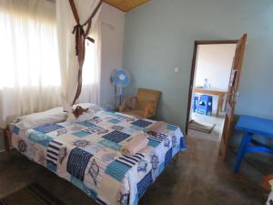 a bedroom with a bed with a cat sitting on it at Gateway Guest House in Monkey Bay