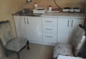 a small kitchen with a sink and a chair at Guest House Olga in Budva
