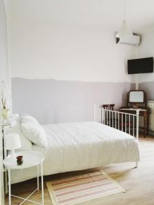 B&B Casa Dalma في سان مينياتو: غرفة نوم بيضاء مع سرير وطاولة