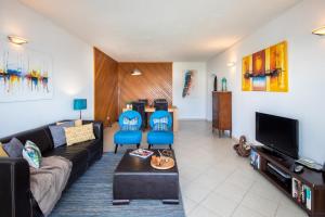 a living room with a couch and a tv at Sea View Downtown - Albufeira in Albufeira