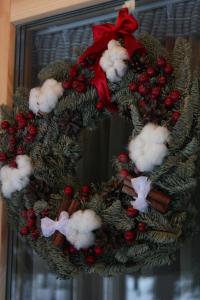 a christmas wreath with a red bow on a window at Baza otdiha Lesnaya Obitel in Roshchino