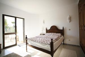 Poço PartidoにあるCASA CARVOEIROのベッドとガラスの引き戸のある寝室