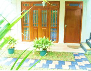 a front door of a house with two potted plants at Kandy Royal Resort in Kandy