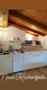 a kitchen with white cabinets and a microwave at Ferienwohnung Holiday Lienz in Lienz