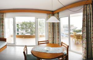 una sala da pranzo con tavolo e balcone di Apartamentos Villa Sirena a Cala Figuera