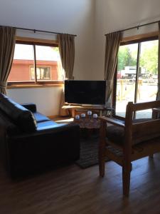 a living room with a couch and a flat screen tv at Complejo Loncopangue Lodge in Loncopangue