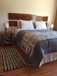a bedroom with a large bed with a wooden headboard at Complejo Loncopangue Lodge in Loncopangue +28 photos