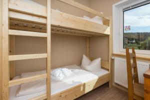 a bunk bed in a room with a window at Campingplatz am Treidlerweg in Königstein an der Elbe