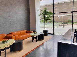 un vestíbulo de oficina con un sofá naranja y dos mesas en RQ Antofagasta, en Antofagasta