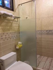 a bathroom with a toilet and a glass shower at Luck Homestay in Jiufen