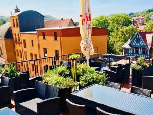 einen Balkon mit Tischen, Stühlen und einem Sonnenschirm in der Unterkunft Hostel & Pension Alte Brauerei in Eisenach