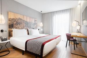 a hotel room with a bed and a desk at Eurostars Porto Centro in Porto