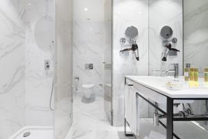 a white bathroom with a shower and a sink at Eurostars Porto Centro in Porto +45 photos