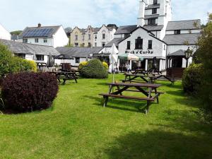 a group of picnic tables in the grass near a building at The Pack o' Cards in Combe Martin