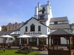 a restaurant with tables and umbrellas in front of a building at The Pack o' Cards in Combe Martin +25 photos