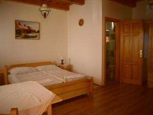 A bed or beds in a room at Nosztalgia Vendégház