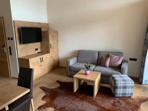 ein Wohnzimmer mit einem Sofa und einem Tisch in der Unterkunft Panorama Apart Weisses Rössl in Reith bei Seefeld
