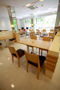 un restaurante con mesas y sillas de madera en S3 Residence Park, en Bangkok