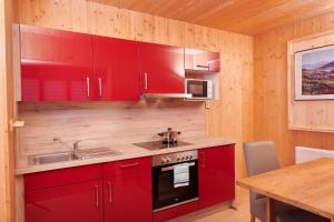 a kitchen with red cabinets and a sink at Gästehaus Aquilin in Sankt Pölten