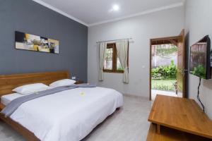 1 dormitorio con cama blanca y mesa de madera en The Uma Guesthouse, en Canggu 26 fotos más