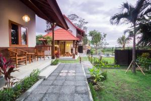 a patio of a house with a table and chairs at The Uma Guesthouse in Canggu