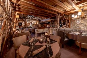 a restaurant with tables and chairs in a room with wooden ceilings at Hotel Eterlou in Méribel