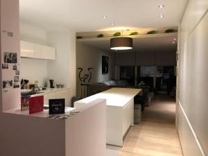 a kitchen with a white counter and a living room at Home Bruges Cosy Comfort Modern Couple Privacy walking distance City center Kitchen Terrace Garden in Bruges