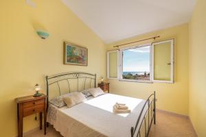 una camera con letto e finestra di AffittaSardegna-Villino Panna a Cala Gonone