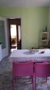 einen Tisch mit zwei rosa Stühlen und einem weißen Tisch in der Unterkunft a due passi dalla neve in Perosa Argentina