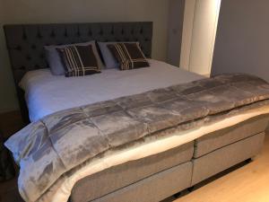 a large bed in a bedroom with a large headboard at Home Bruges Cosy Comfort Modern Couple Privacy walking distance City center Kitchen Terrace Garden in Bruges
