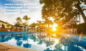 - une vue sur la piscine et le coucher du soleil dans l'établissement Hotel Castelo, à Gravatal