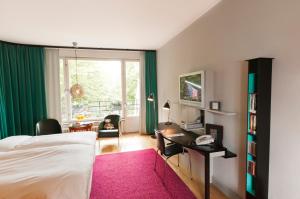 a bedroom with a bed and a desk and a window at Hotel Rival in Stockholm