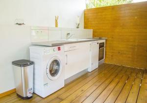 a kitchen with a washing machine and a sink at Gîte Hibiscus Destrellan in Baie-Mahault