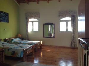 1 Schlafzimmer mit 2 Betten und 2 Fenstern in der Unterkunft Dogis Retreat in Ayia Evfimia