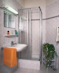 a bathroom with a shower and a sink at Hotel - Restaurant Kurhaus Klotzsche in Dresden