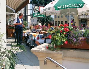 un grupo de personas sentadas en una mesa en una floristería en Hotel - Restaurant Kurhaus Klotzsche en Dresden