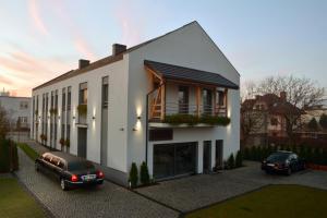 a white house with two cars parked in front of it at Villa Vip in Gniezno