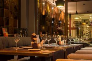 a restaurant with a long table with wine glasses at Hotel Oppium Restaurant & Garden in Ruse