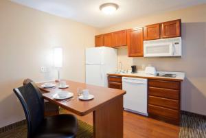 a small kitchen with a table and a refrigerator at GrandStay Residential Suites Rapid City in Rapid City