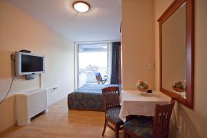 a room with a table and a bed and a television at Studio Apartmani Bijeli Delfin in Biograd na Moru