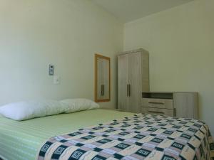 Un dormitorio con una cama y un armario. en Residencial Maria Idia, en Bombinhas