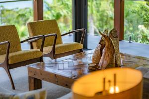 a wooden table with chairs and a wooden table at Mandalay Luxury Retreat in Airlie Beach