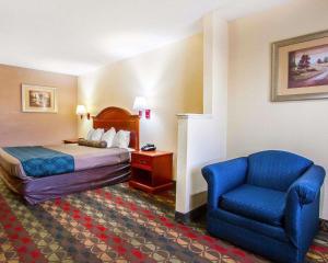 a hotel room with a bed and a chair at Econo Lodge - Prattville in Prattville