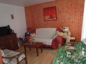 a living room with a teddy bear sitting on a couch at Les Elfes in Saint-Jean