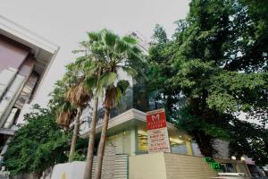 a no parking sign in front of a building with palm trees at Monarch Luxur - Infantry Road in Bengaluru